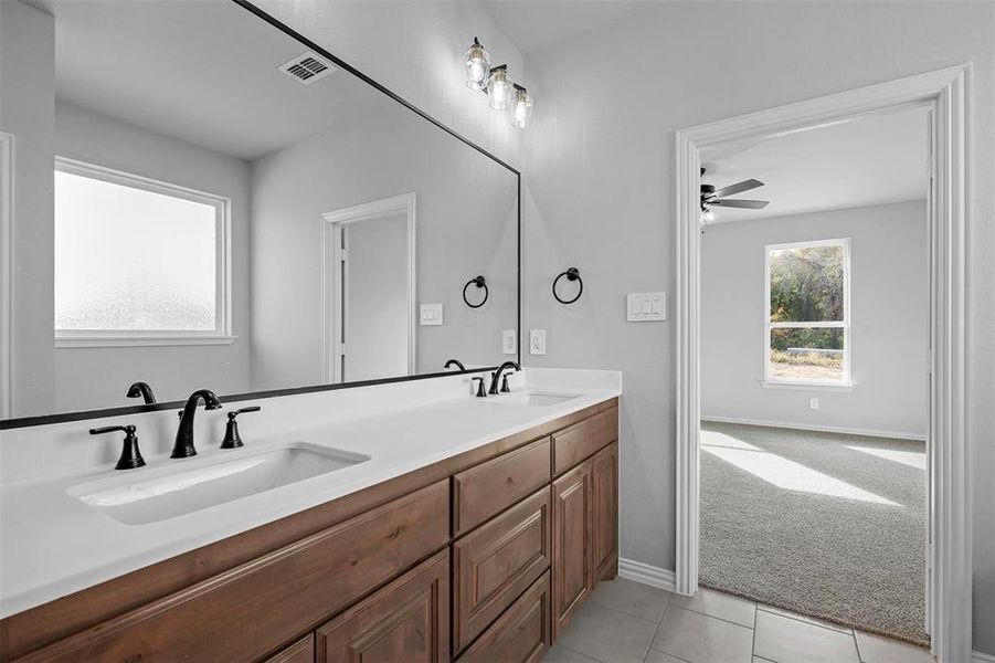 Bathroom with vanity, ceiling fan, and tile patterned floors