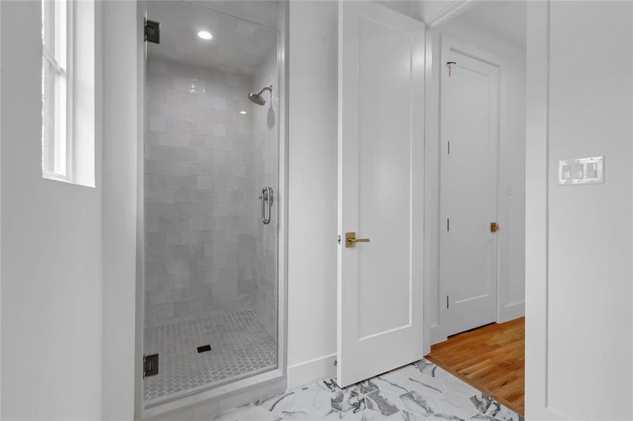 Bathroom featuring a stall shower, light wood finished floors, and recessed lighting