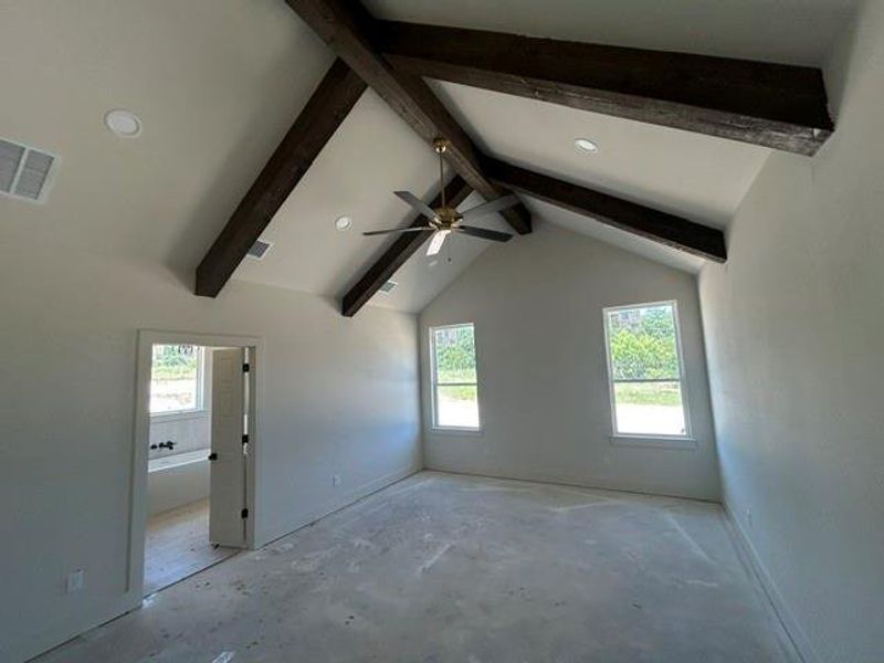 Vaulted ceiling featuring exposed wood beams and a ceiling fan