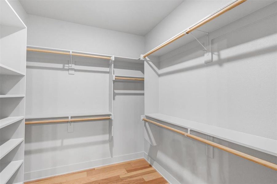 Spacious closet with light wood-style flooring Spacious closet with light wood-style flooring