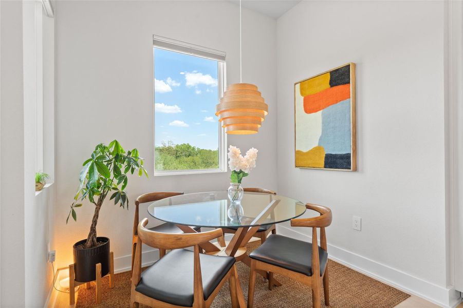 A cozy dining area features a unique wooden pendant light, illuminating a glass-top table with a serene outdoor view. A cozy dining area features a unique wooden pendant light, illuminating a glass-top table with a serene outdoor view.