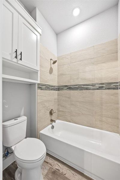 Full bath featuring shower / tub combination, wood finished floors, and a textured ceiling