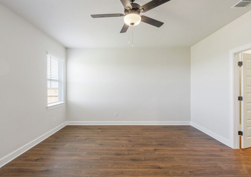 Master bedroom with a large window overlooking the private backyard