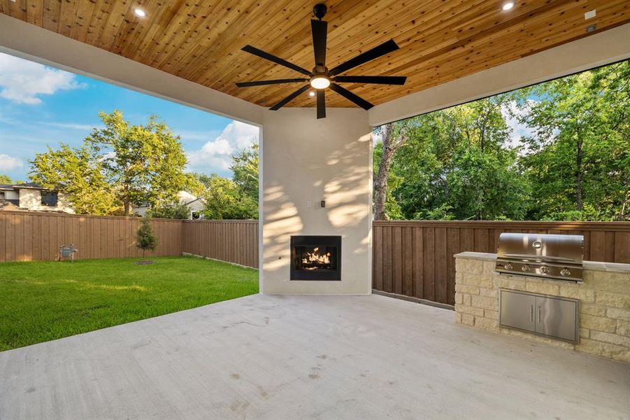 Expansive covered patio featuring a wood-panel ceiling with recessed lighting and a ceiling fan