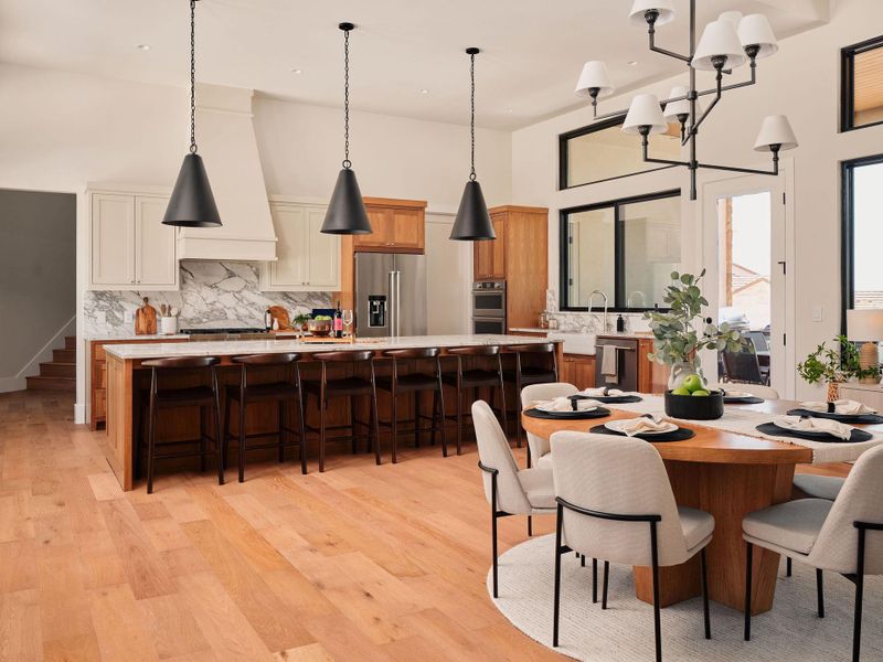 An open-concept living space highlights a grand kitchen island and a charming dining area. An open-concept living space highlights a grand kitchen island and a charming dining area.