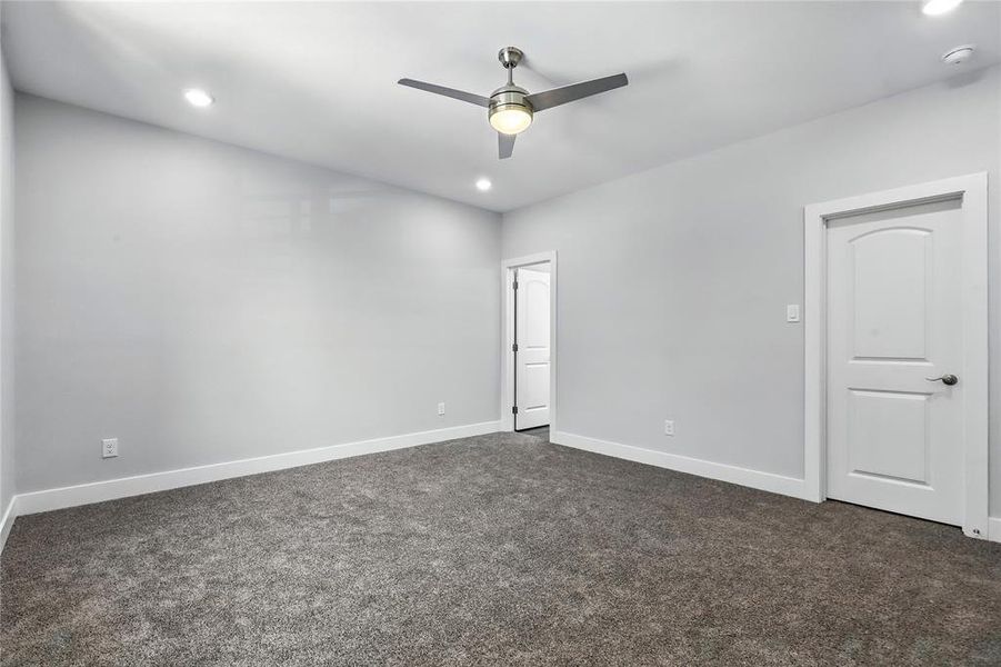 Spare room with a ceiling fan, dark colored carpet, and recessed lighting
