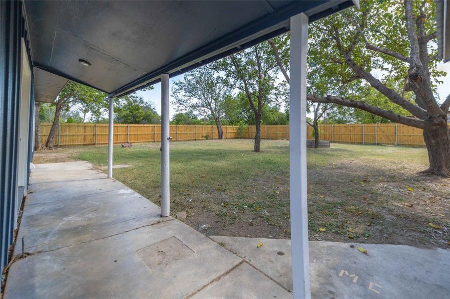 Fenced backyard with a patio area Fenced backyard with a patio area
