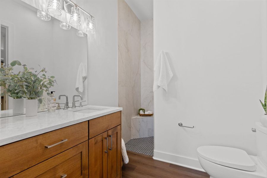 Full bathroom with toilet, wood finished floors, walk in shower, and vanity Full bathroom with toilet, wood finished floors, walk in shower, and vanity