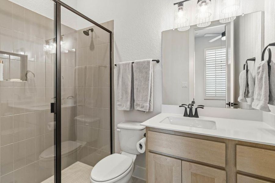 Modern fixtures and a spacious walk-in shower elevate this pristine primary bathroom.