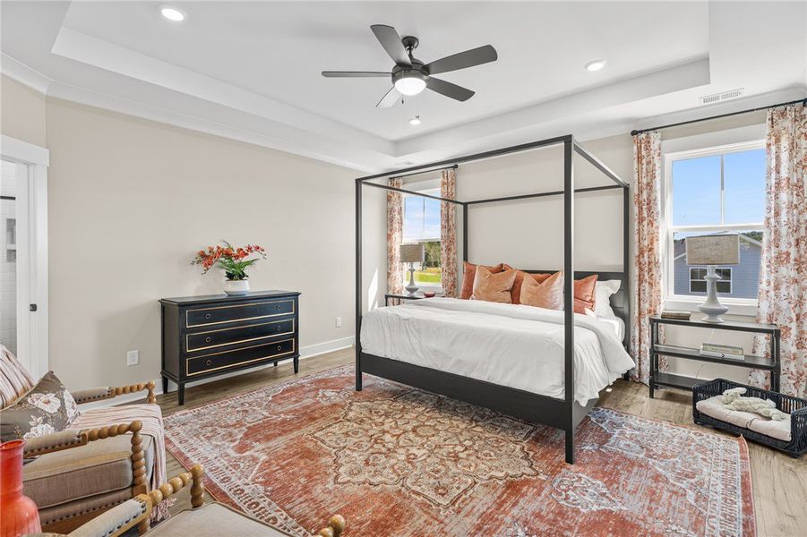 This spacious primary bedroom offers elegant crown