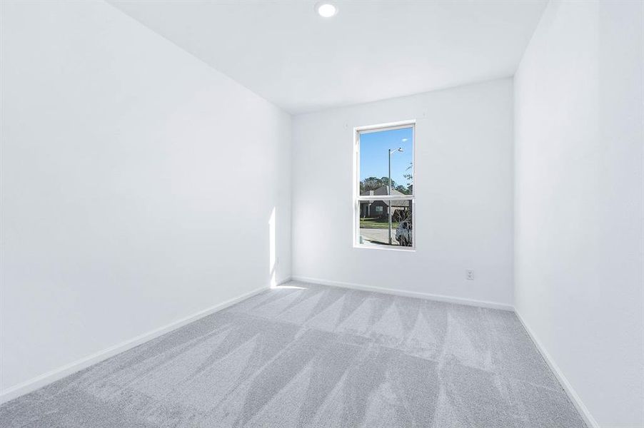 This secondary bedroom offers soft carpeting, natural light, and a peaceful ambiance – perfect for guests or family members.