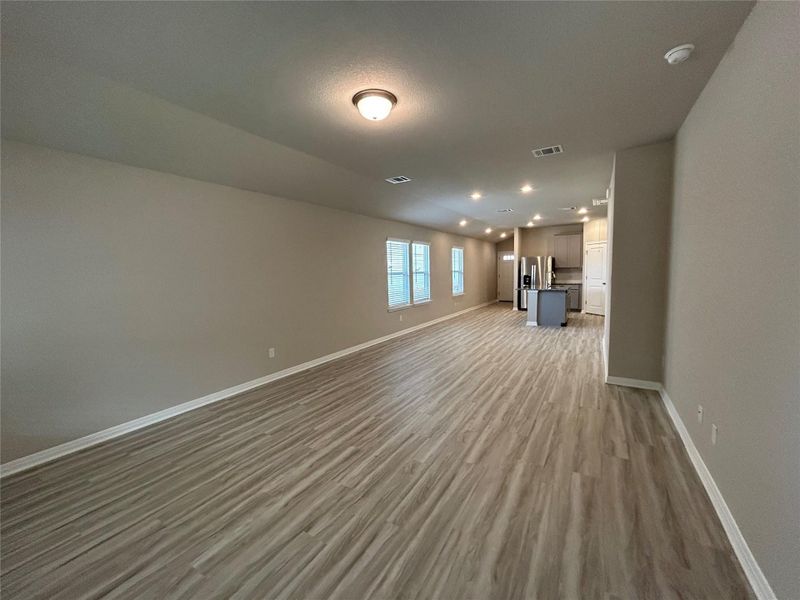 Unfurnished living room featuring wood finished floors and recessed lighting Unfurnished living room featuring wood finished floors and recessed lighting
