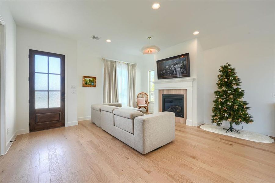 Living room featuring a tiled fireplace and light hardwood / wood-style floors