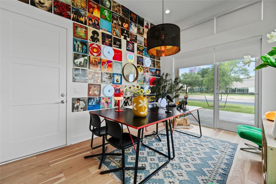 Hardwood-finish flooring complements a bright room featuring a three-panel interior door and a full-light glass door