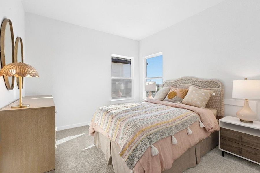 Bedroom featuring light carpet and baseboards Bedroom featuring light carpet and baseboards