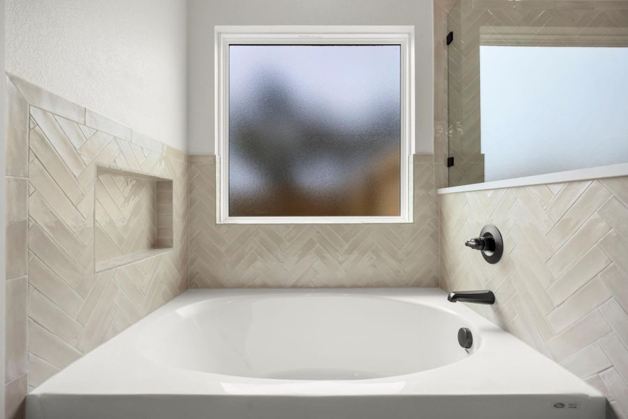 Herringbone tiled walls embrace this pristine bathtub, creating a soothing sanctuary. Herringbone tiled walls embrace this pristine bathtub, creating a soothing sanctuary.