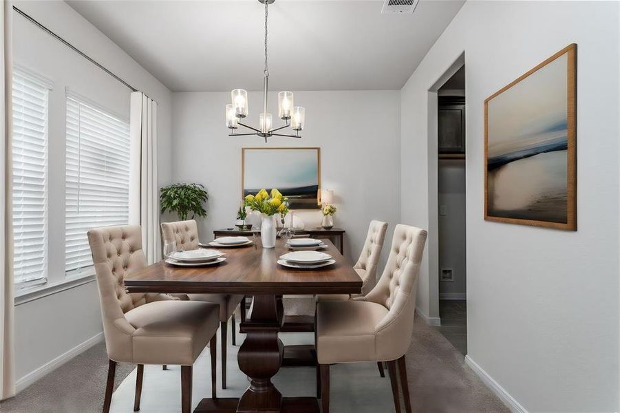 The formal dining room is perfect for family gatherings and entertaining. Located just off the kitchen, this space features plush carpeting and large windows that fill the room with natural light. The modern chandelier adds a touch of elegance, creating a warm and inviting atmosphere for your dinners and special occasions. Photos are from another Rylan floor plan.