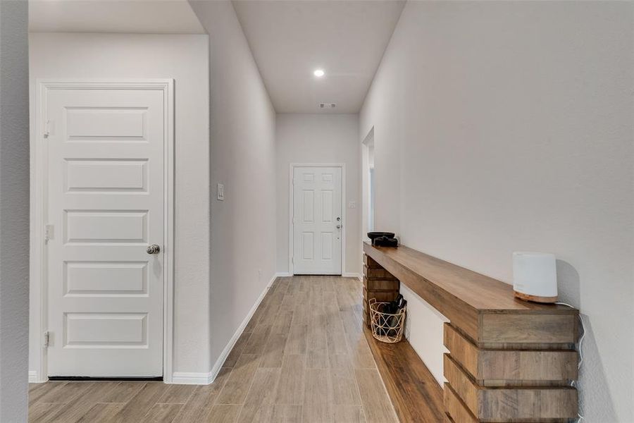 Hall with light wood-style flooring and recessed lighting Hall with light wood-style flooring and recessed lighting