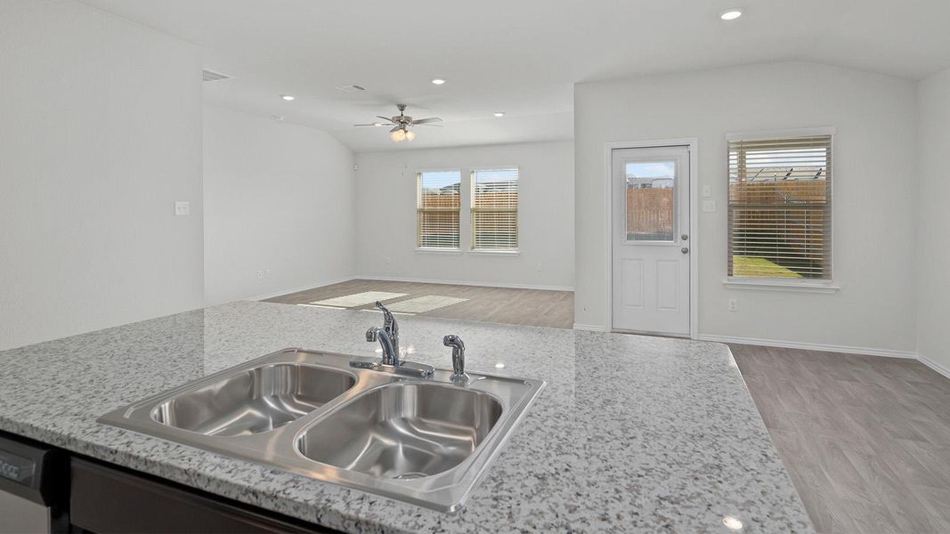 Kitchen featuring light wood finished floors, recessed lighting, open floor plan, ceiling fan, and vaulted ceiling
