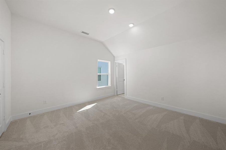 Unfurnished room with vaulted ceiling, light carpet, and recessed lighting Unfurnished room with vaulted ceiling, light carpet, and recessed lighting