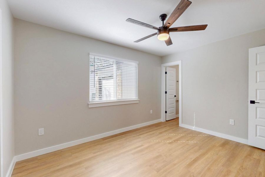 Spare room featuring baseboards, light wood-type flooring, and a ceiling fan