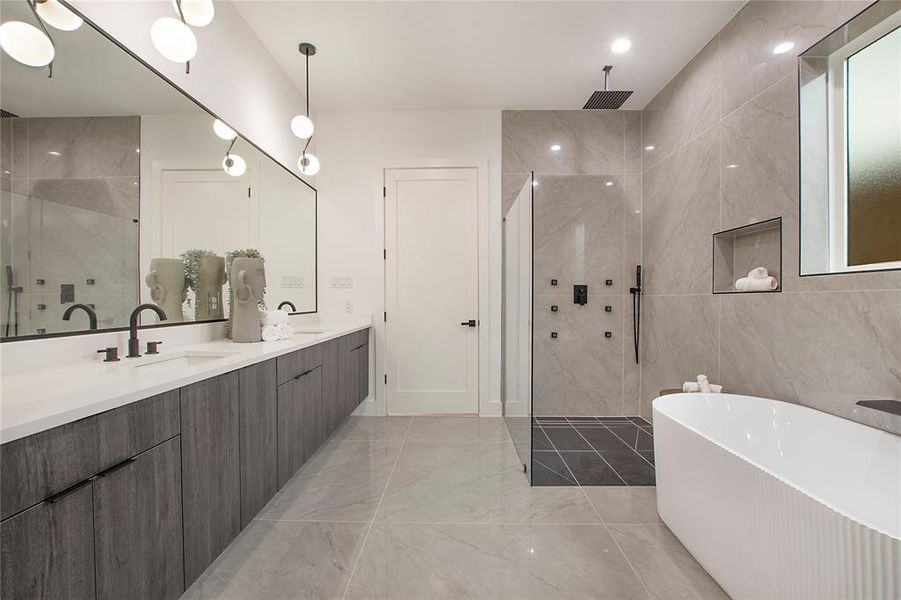 Bathroom with vanity, shower with separate bathtub, and tile walls