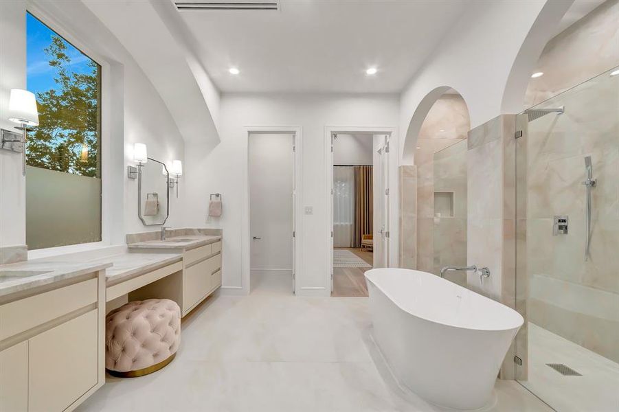 Full bathroom featuring a freestanding bath, double vanity, a tile shower, recessed lighting, and light tile patterned floors Full bathroom featuring a freestanding bath, double vanity, a tile shower, recessed lighting, and light tile patterned floors
