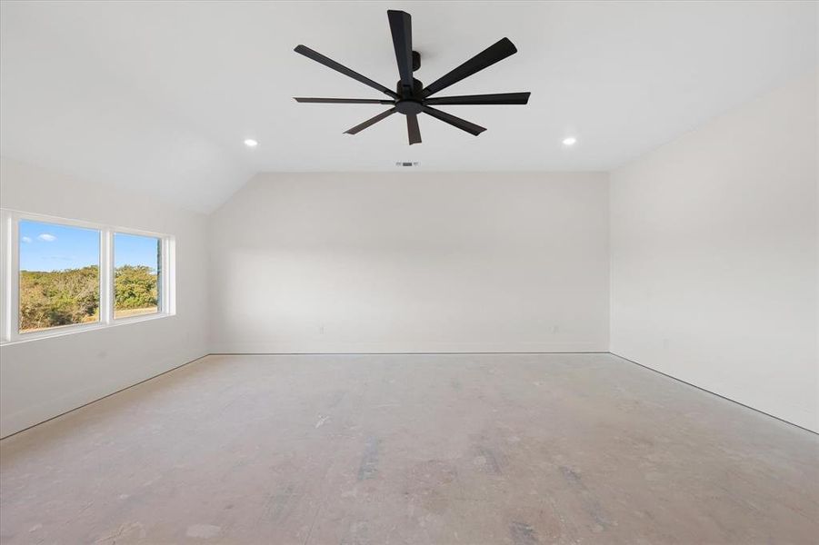 Unfurnished room with lofted ceiling, a ceiling fan, and recessed lighting