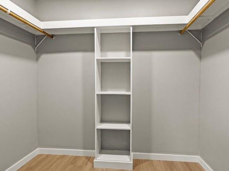Walk in closet with light wood-type flooring
