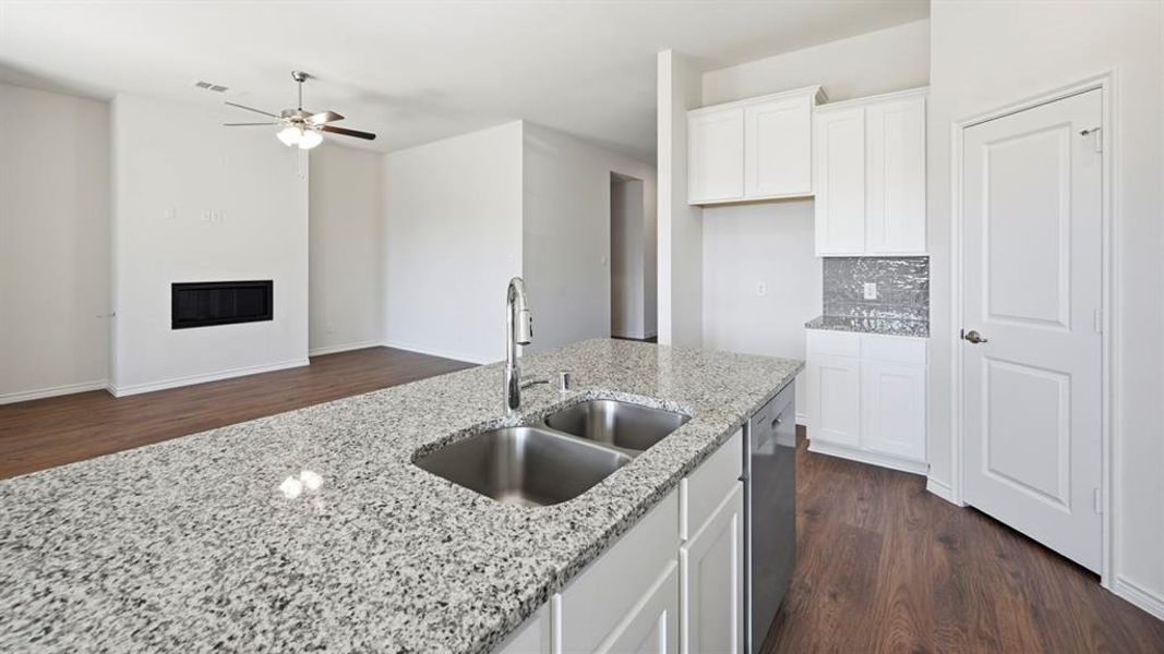 Kitchen island featuring a dual stainless steel sink and speckled granite countertop Kitchen island featuring a dual stainless steel sink and speckled granite countertop