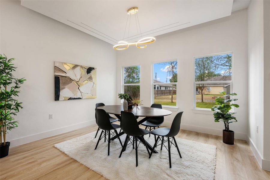 Dining room featuring light wood-style floors and suspended lighting Dining room featuring light wood-style floors and suspended lighting