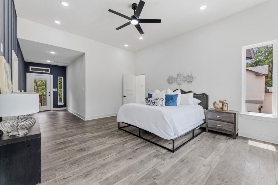 A tranquil bedroom retreat features a private balcony access and modern wood flooring.