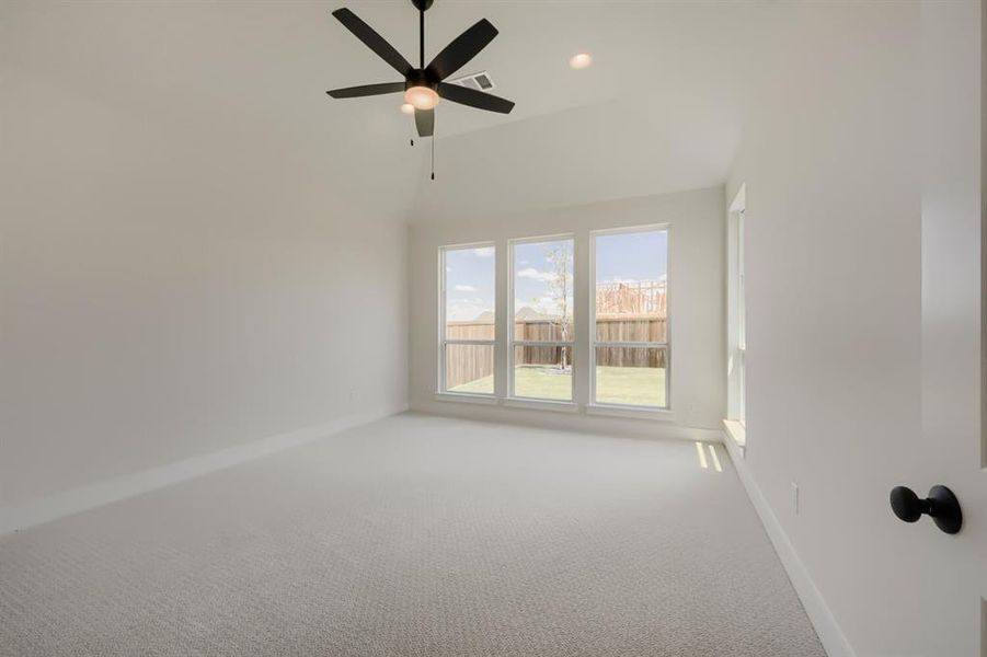 Bright interior with vaulted ceiling and light carpeting