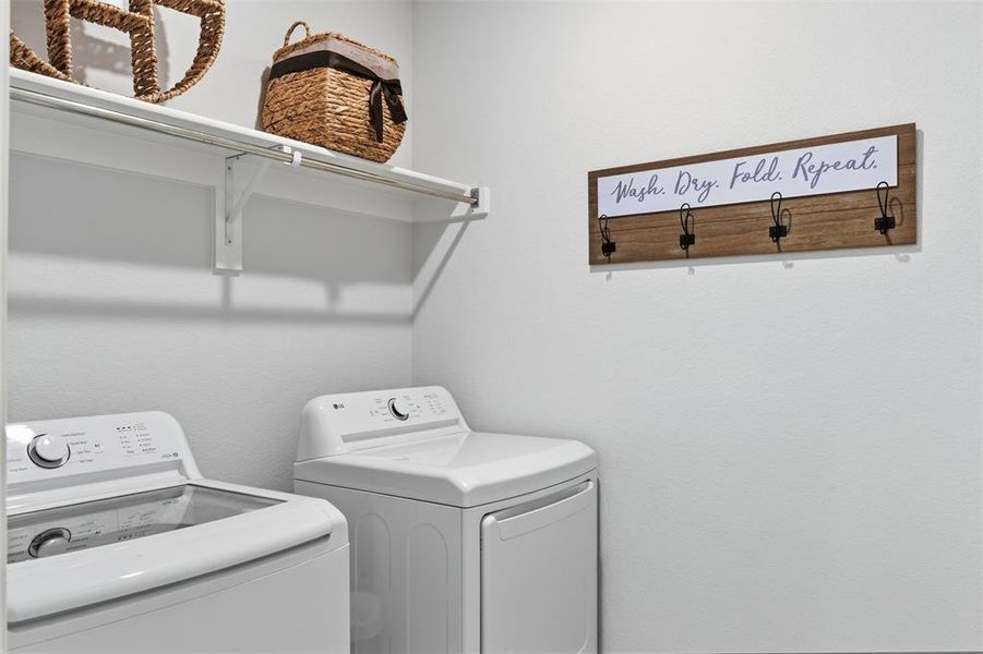 Dedicated laundry area featuring a white wall shelf with an integrated hanging rod and a wall-mounted wooden rack with black hooks Dedicated laundry area featuring a white wall shelf with an integrated hanging rod and a wall-mounted wooden rack with black hooks