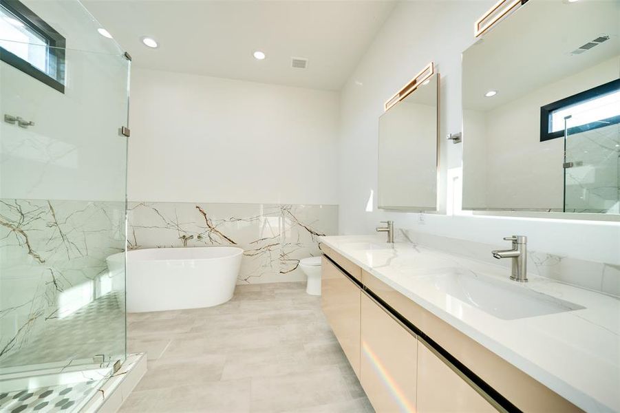 Full bathroom featuring shower with separate bathtub, toilet, tile walls, vanity, and tile patterned flooring