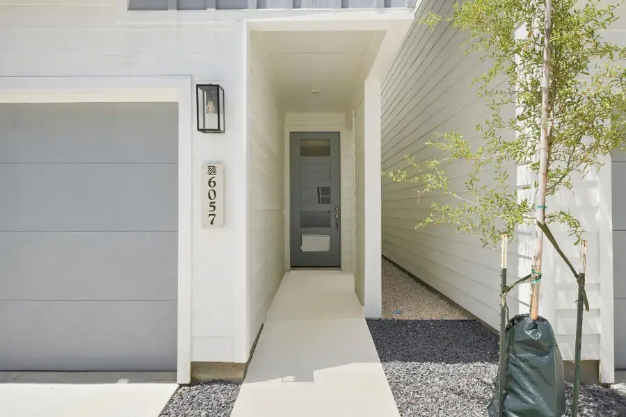 Modern front entry featuring a covered approach, contemporary exterior finishes, and convenient access from the driveway. Modern front entry featuring a covered approach, contemporary exterior finishes, and convenient access from the driveway.