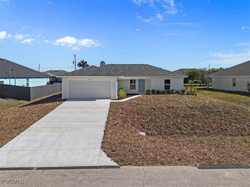 Ranch-style house featuring driveway, an attached garage, stucco siding, and roof with shingles