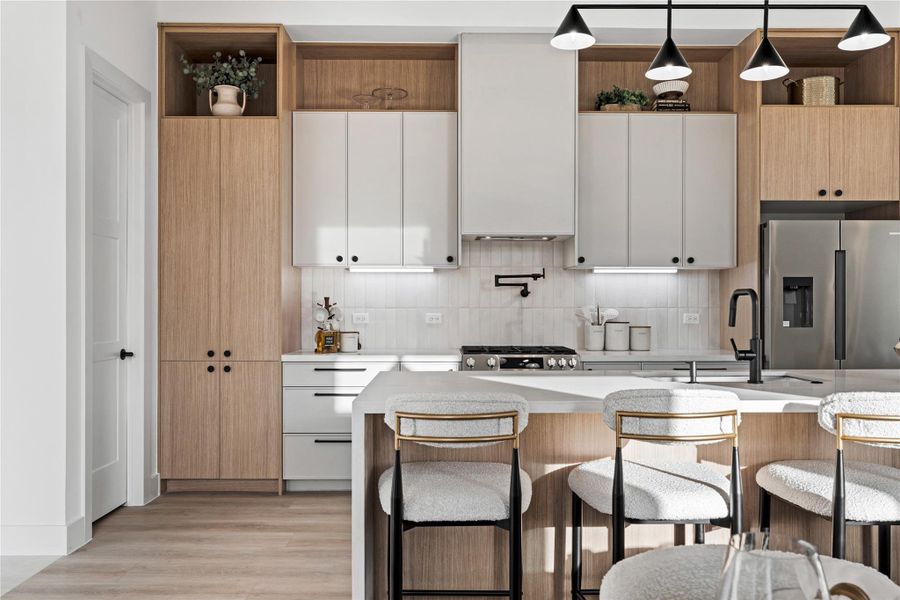 Warm grain cabinetry wraps the space in subtle texture, balanced by crisp white surfaces and streamlined hardware. Designed with precision, the kitchen feels both modern and inviting.