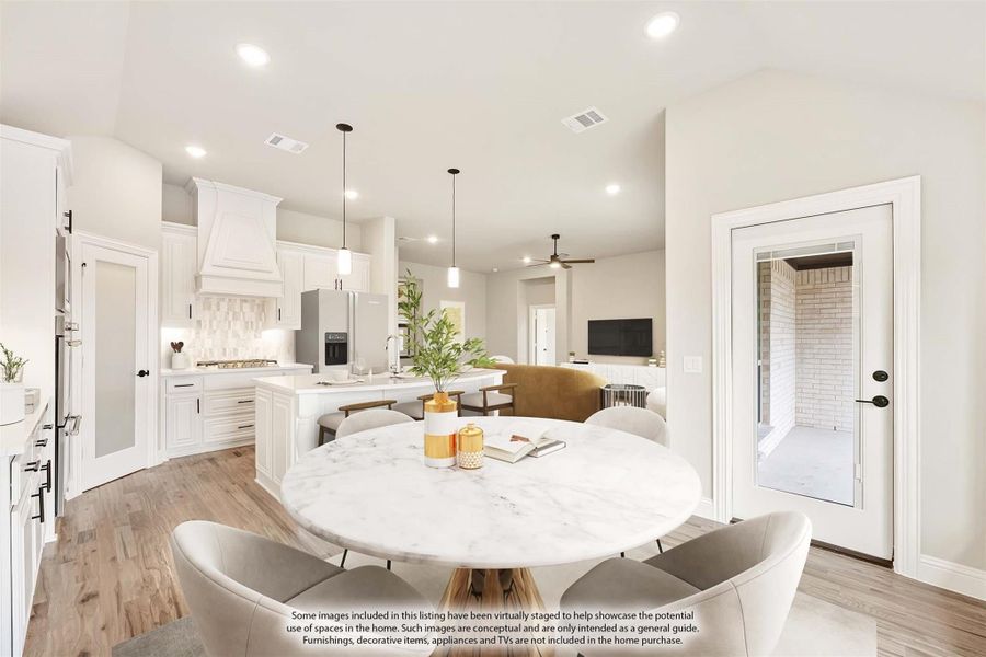 Open-concept dining area with round marble table, white kitchen, and living room visible in background Open-concept dining area with round marble table, white kitchen, and living room visible in background