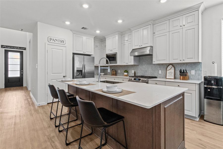 Elegant kitchen with a spacious island, sleek stainless steel appliances, and abundant cabinetry. Elegant kitchen with a spacious island, sleek stainless steel appliances, and abundant cabinetry.