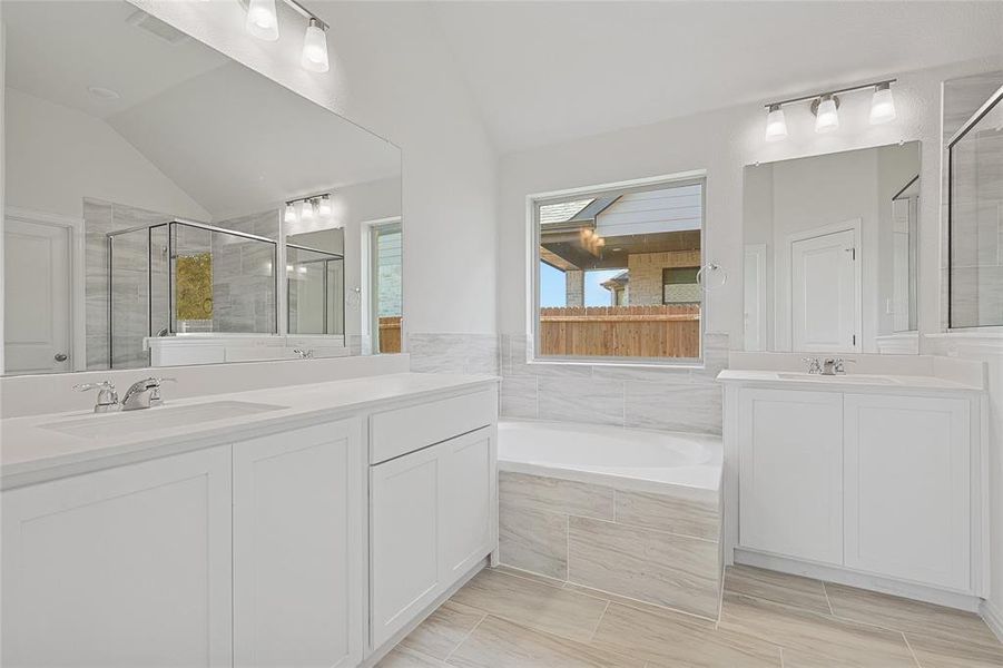 Bathroom with vanity, vaulted ceiling, and plus walk in shower