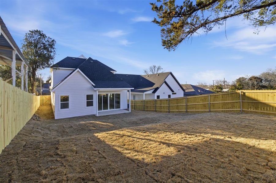 Back of property with a fenced backyard and a patio