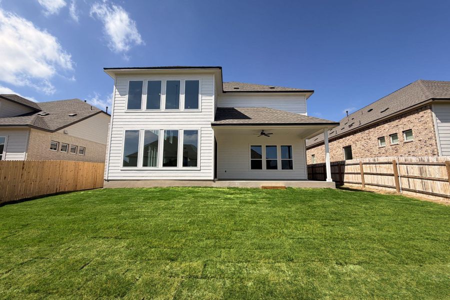 Rear view of house with a patio, ceiling fan, a fenced backyard, and roof with shingles
