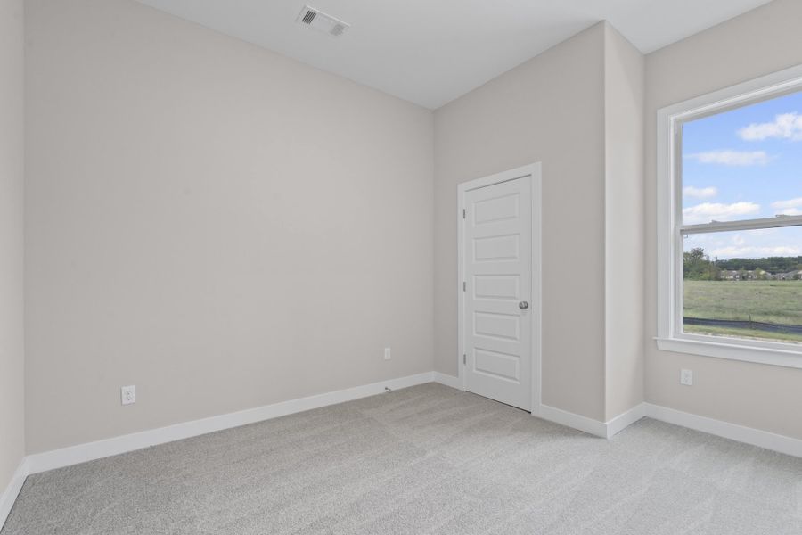Spare room featuring light carpet and baseboards