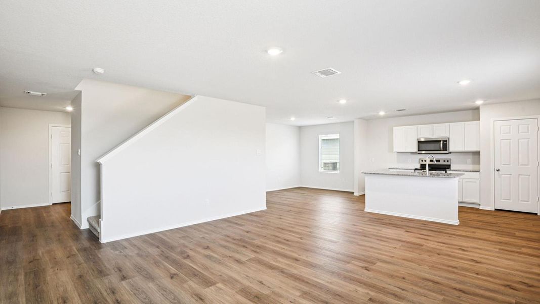 Open-concept living space with wood-finish flooring