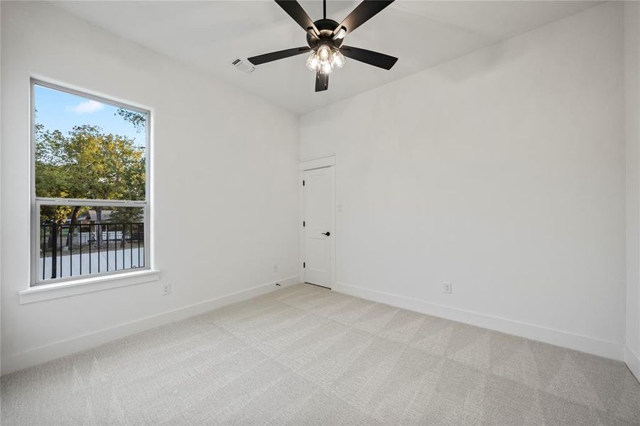 Empty room featuring light carpet and ceiling fan
