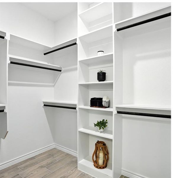 Walk in closet with wood finish floors