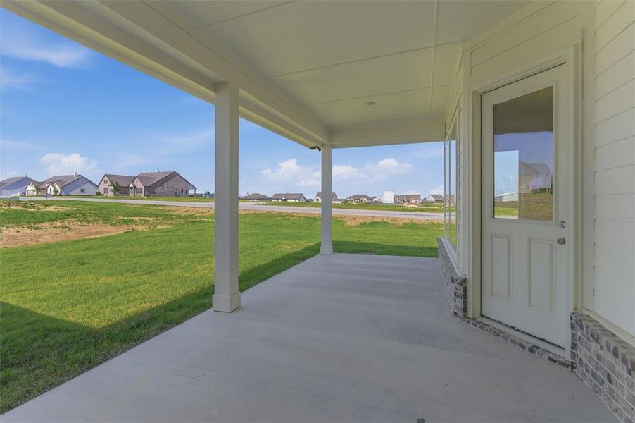 Covered concrete patio with white support columns