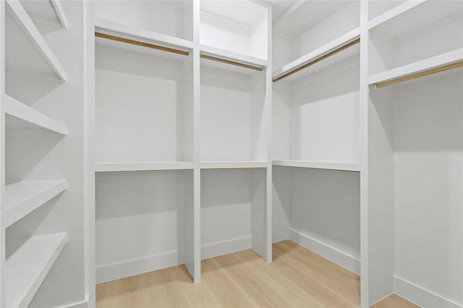 Walk in closet featuring light wood-style floors Walk in closet featuring light wood-style floors