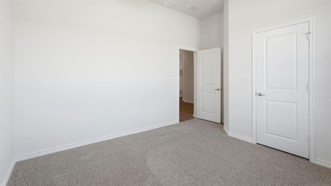 This room features neutral-toned carpet, white walls, and white trim This room features neutral-toned carpet, white walls, and white trim